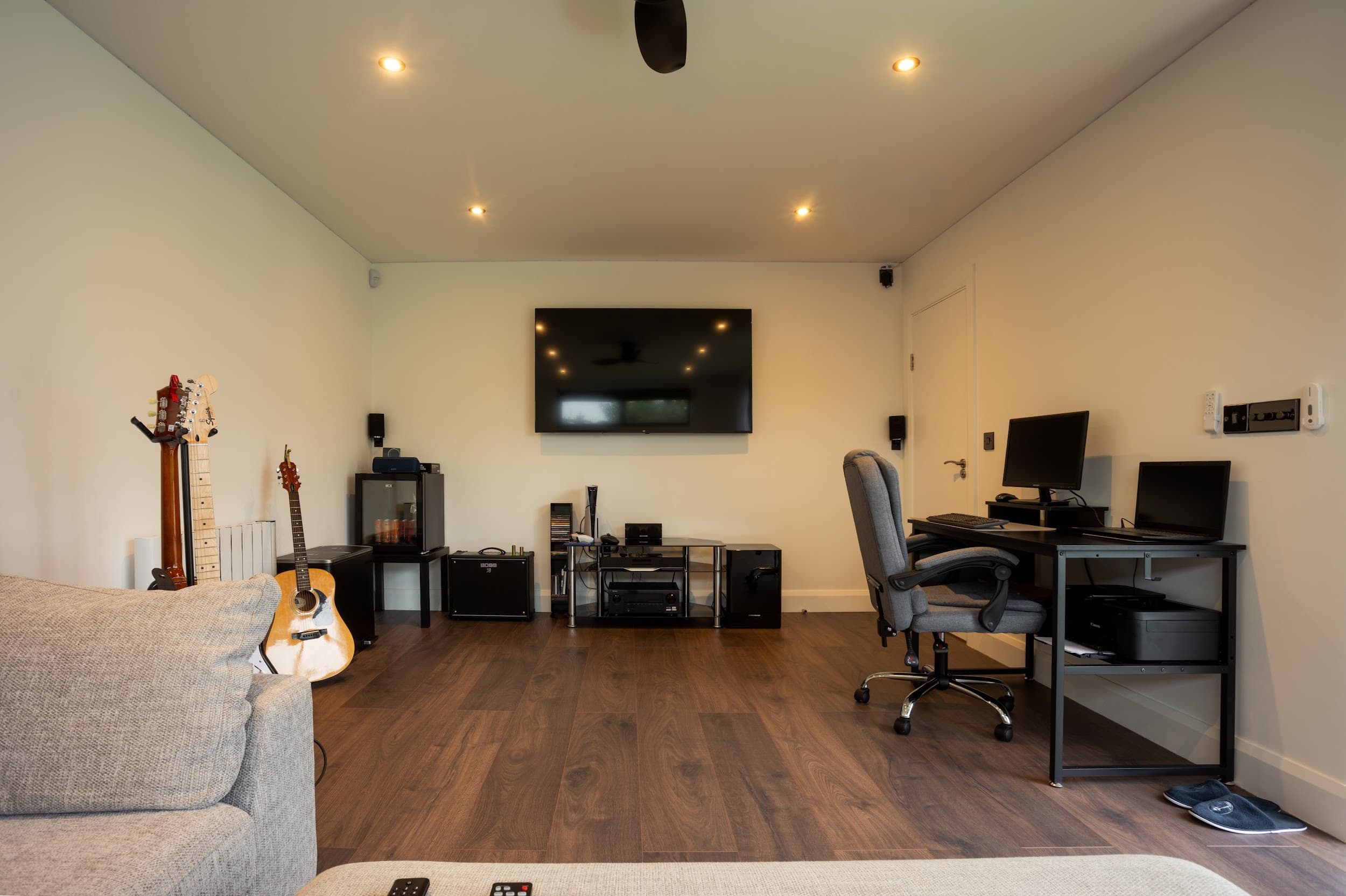Minimalist garden office interior with desk, dual monitors and warm timber finish